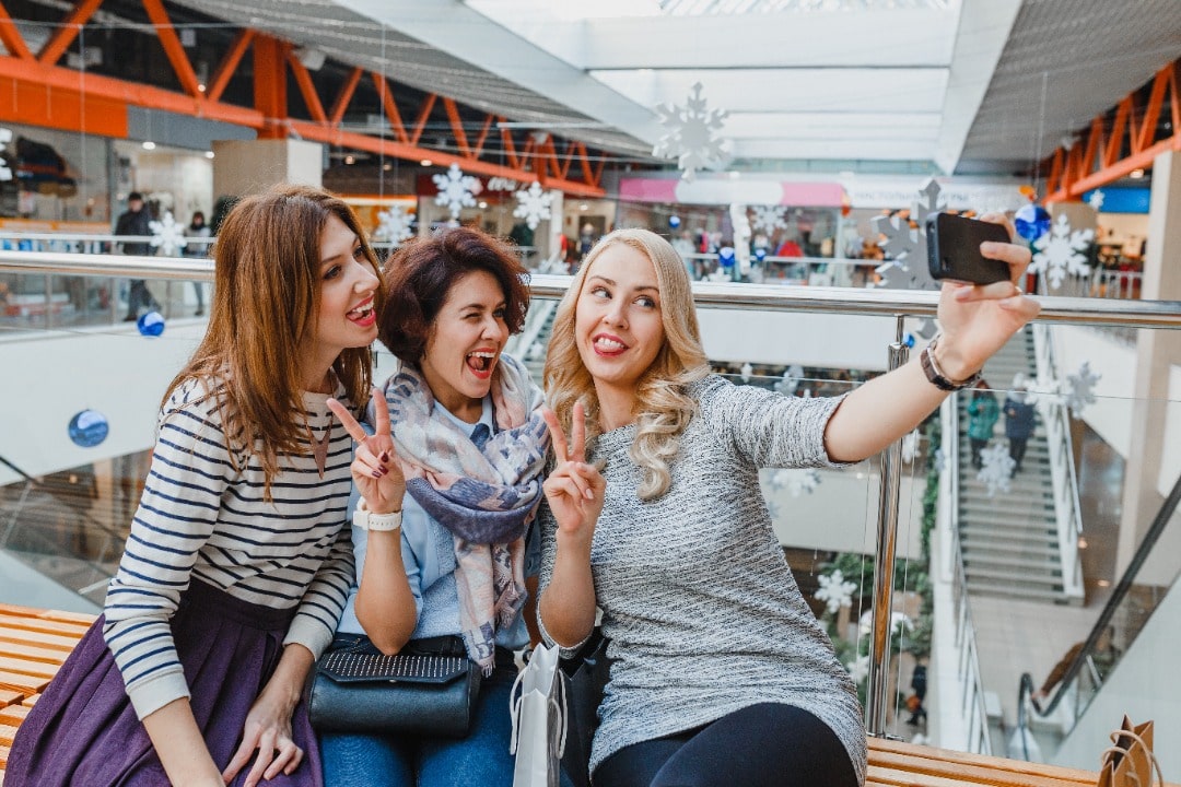 Some friends snap a scavenger hunt selfie at the mall.